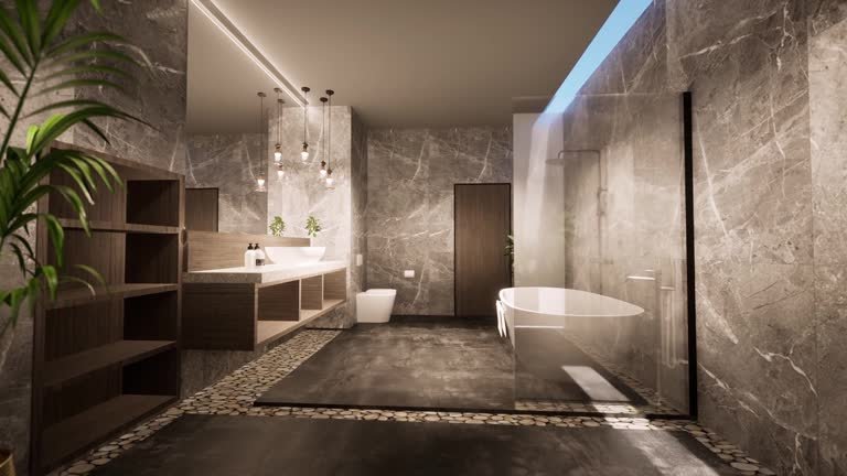 Contemporary bathroom design with dark marble-finish designer wall tiles, freestanding bathtub, and ambient lighting that enhances a luxurious spa-like feel.