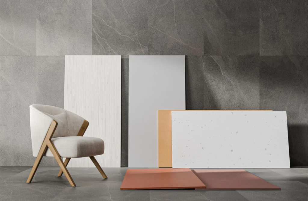 Assorted vitrified tiles samples displayed in various textures and colours alongside a designer chair, showing material variety and finish options for premium interiors.