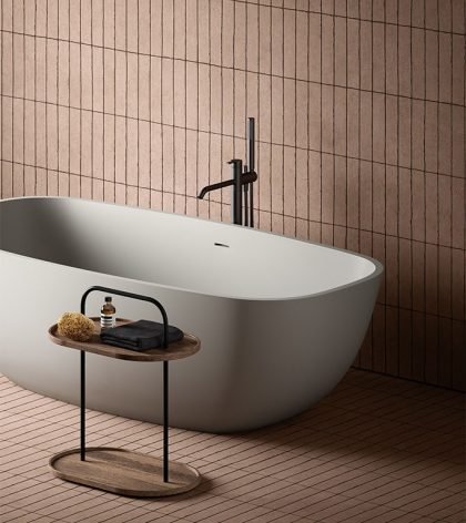 Minimal freestanding bathtub styled with neutral tones expressing timeless bathroom accessories design