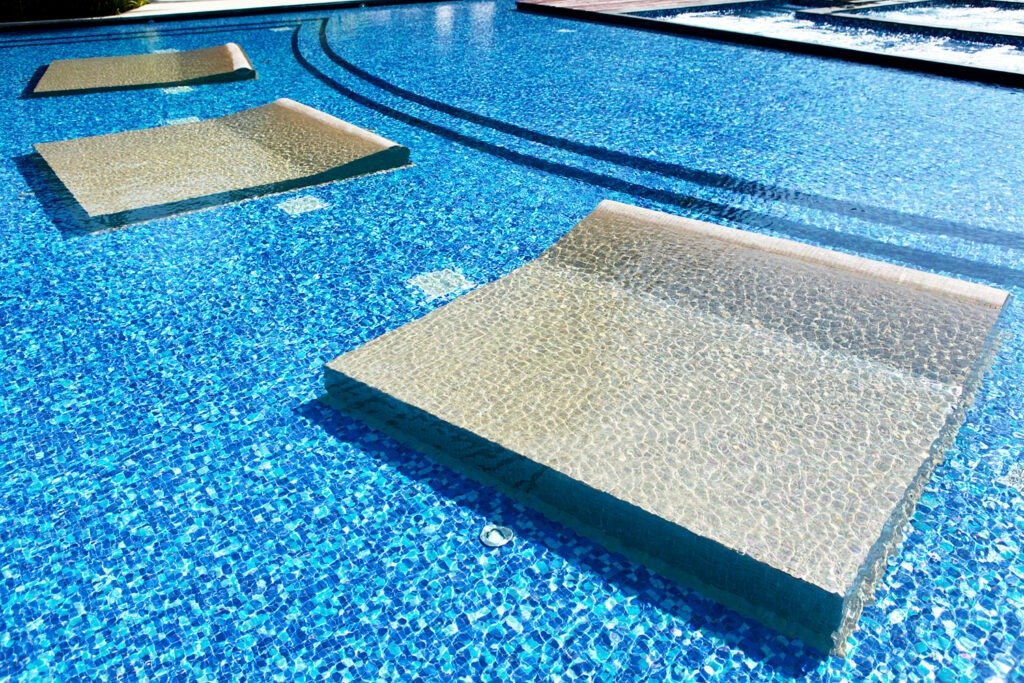 Contemporary poolside tiles paired with outdoor decking to create a serene luxury poolside lounge setting
