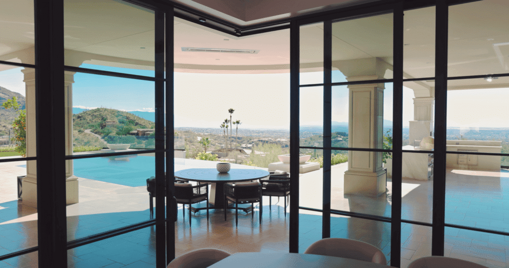 High end aluminium doors and windows opening to an outdoor patio and poolside luxury area