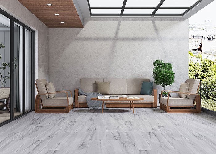 Minimal living space with soft grey stone-finish flooring highlighting elegant Ceramic Tile Design Ideas for contemporary Indian homes with natural light and wooden furniture.
