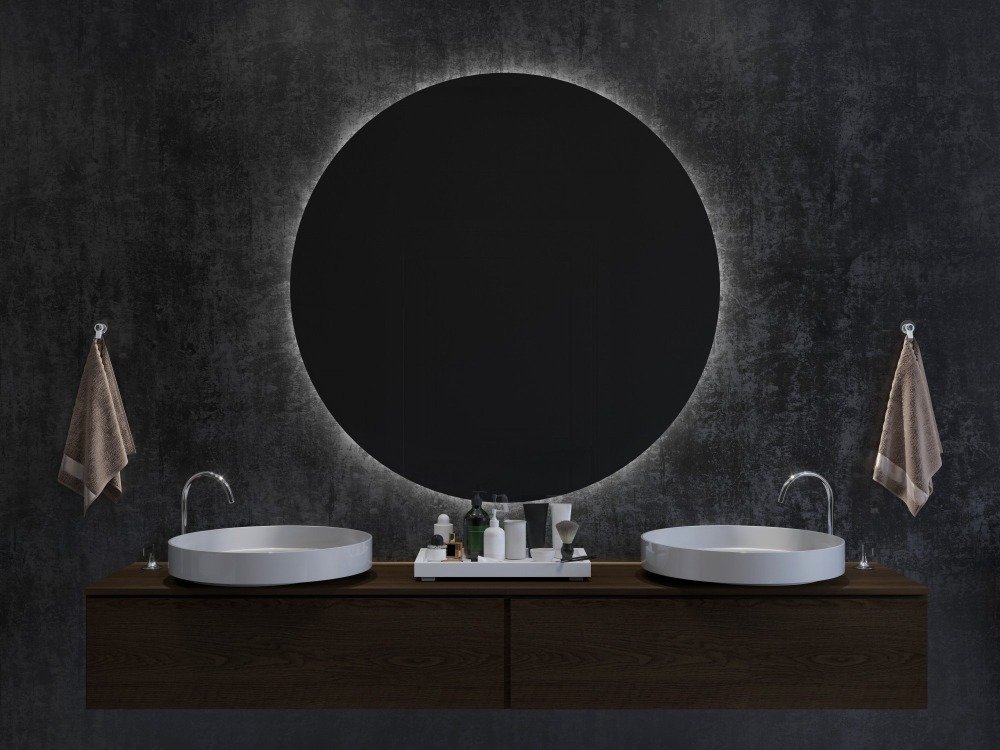 Large circular backlit mirror above dual countertop basins, highlighting LED mirrors for modern bathrooms in minimalist dark-toned bathroom design.